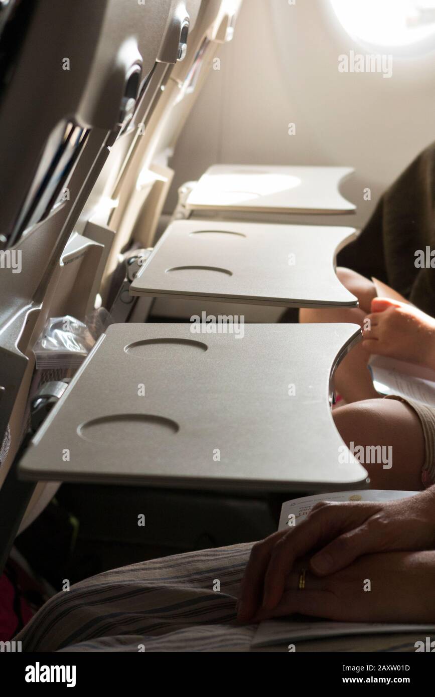 Three passenger seat tray tables in a row, in the full down position