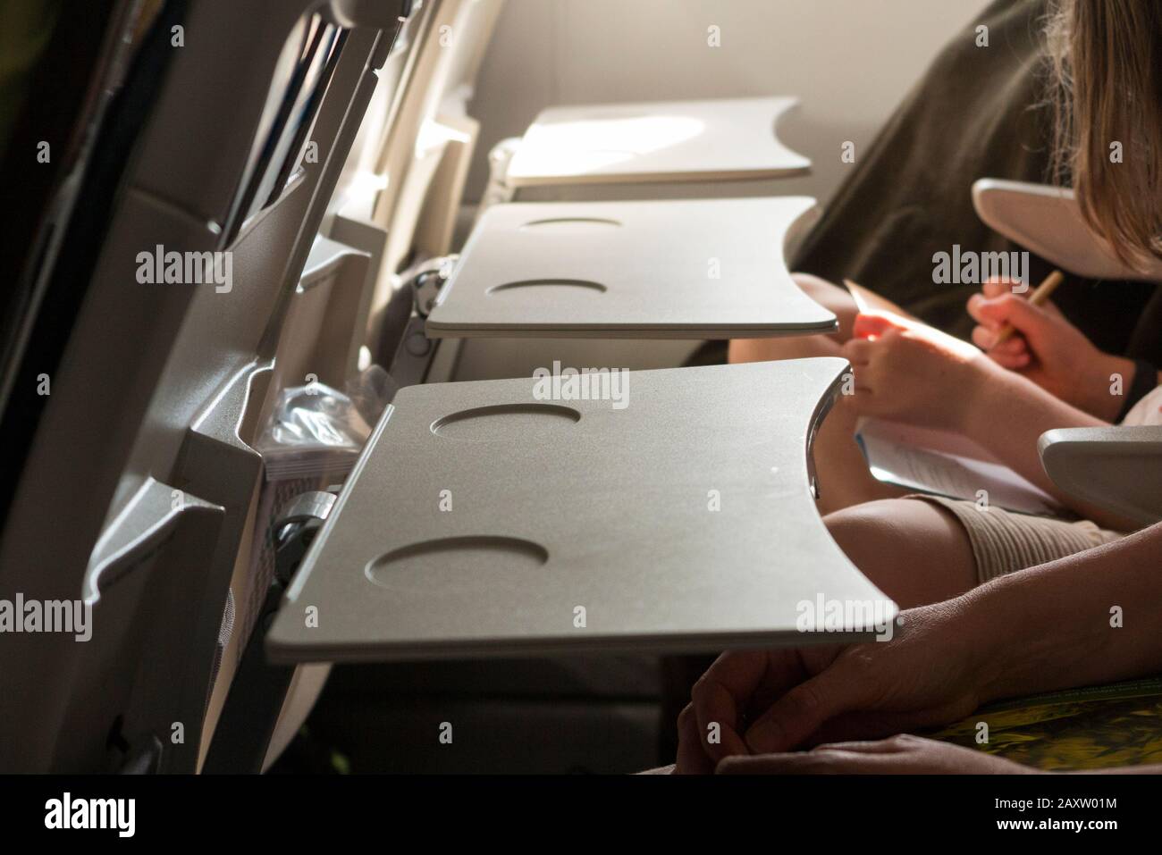 Three passenger seat tray tables in a row, in the full down position