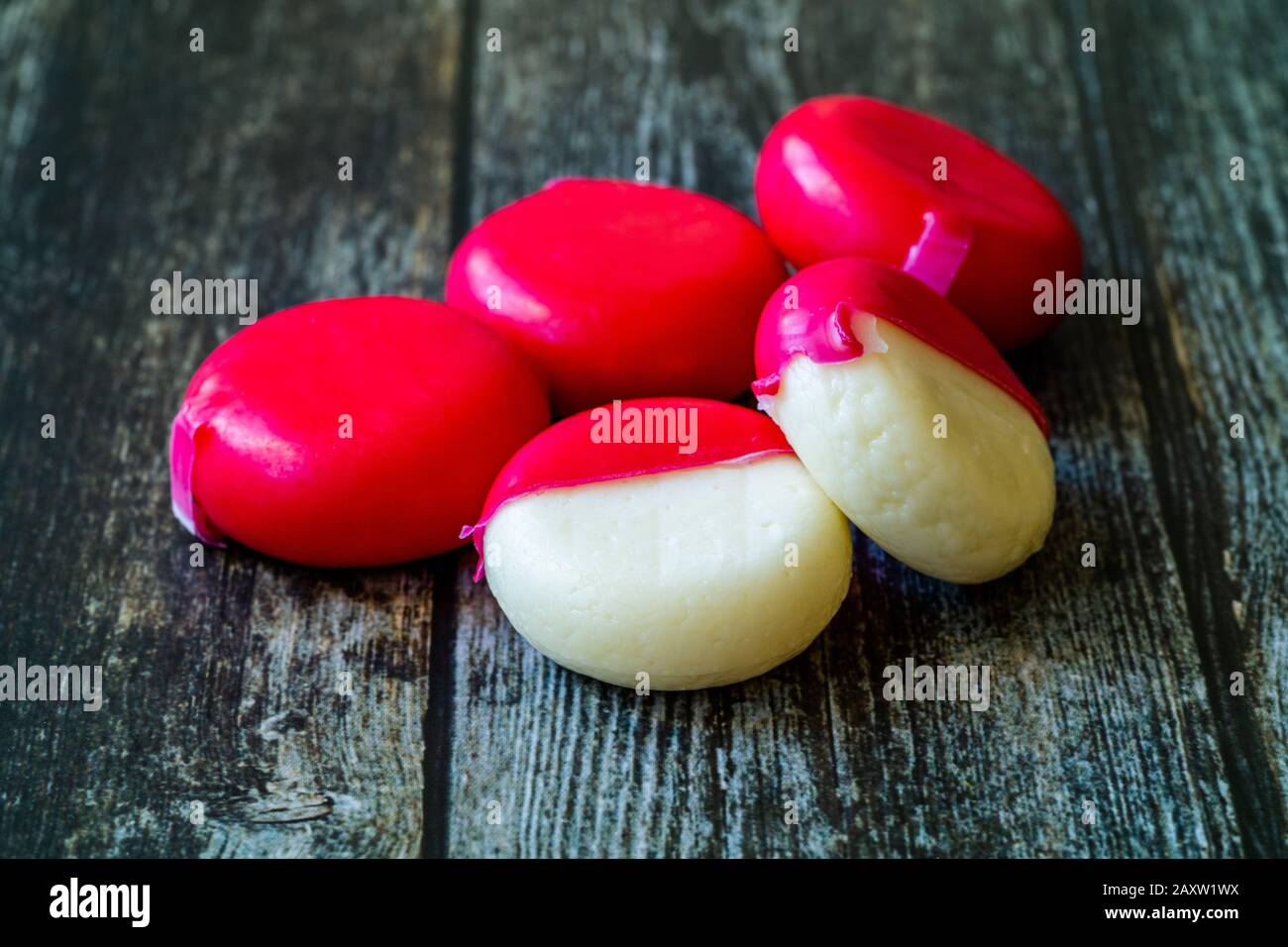 Babybel Cheese in Red Wex on Wooden Surface Ready to Eat. Instant Food