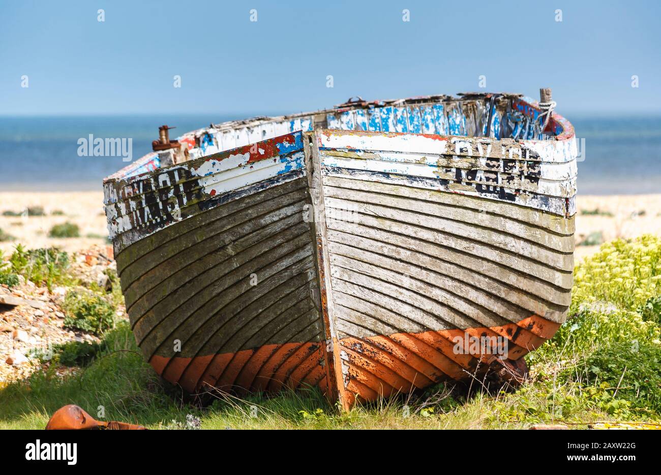 Decaying hull of an old wooden fishing boat abandoned on the shingle ...