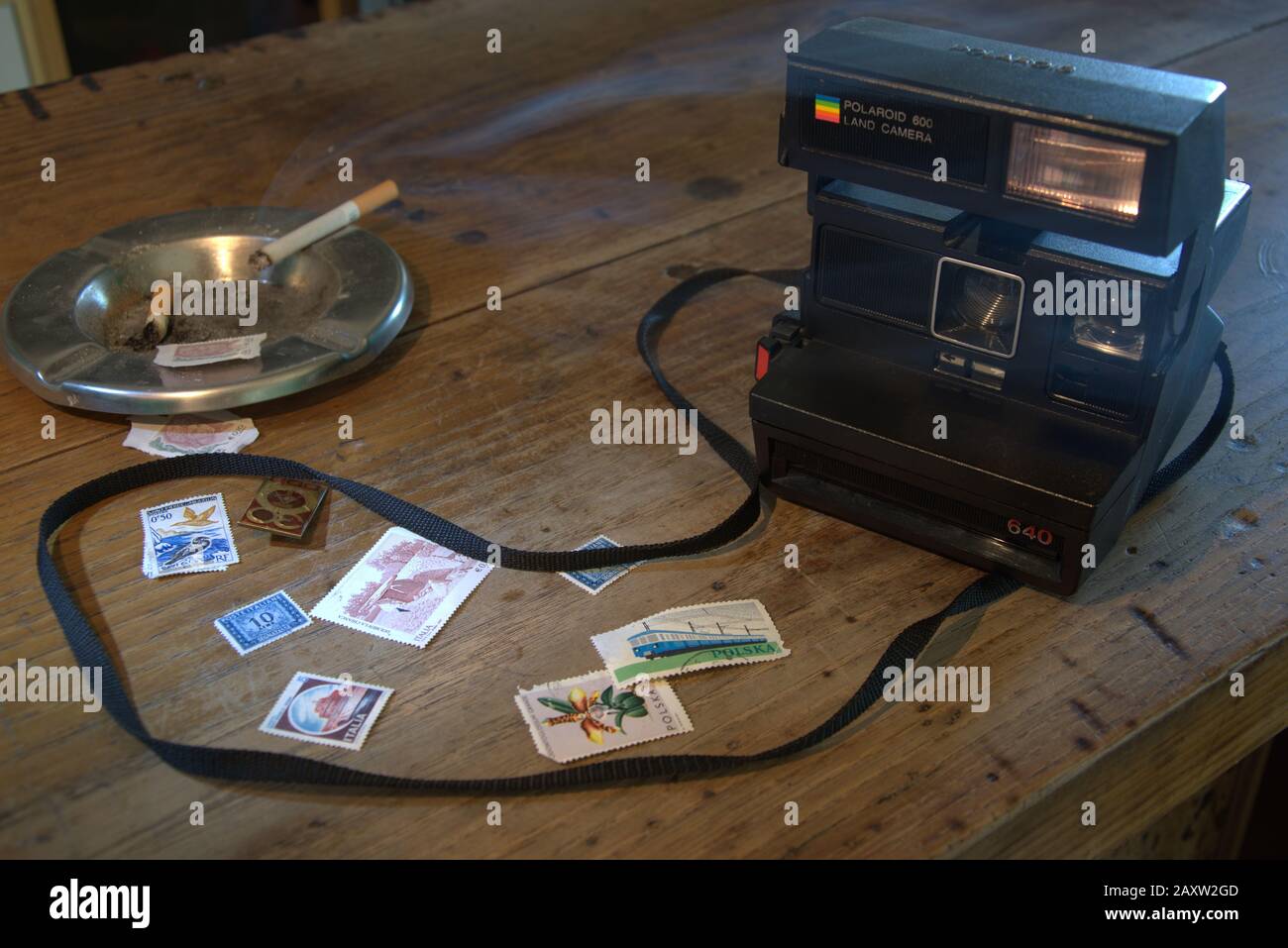 An old polaroid camera, old stamps from Europe (Italy and Poland) and DDR  (East Germany) and a smoking cigarette Stock Photo - Alamy