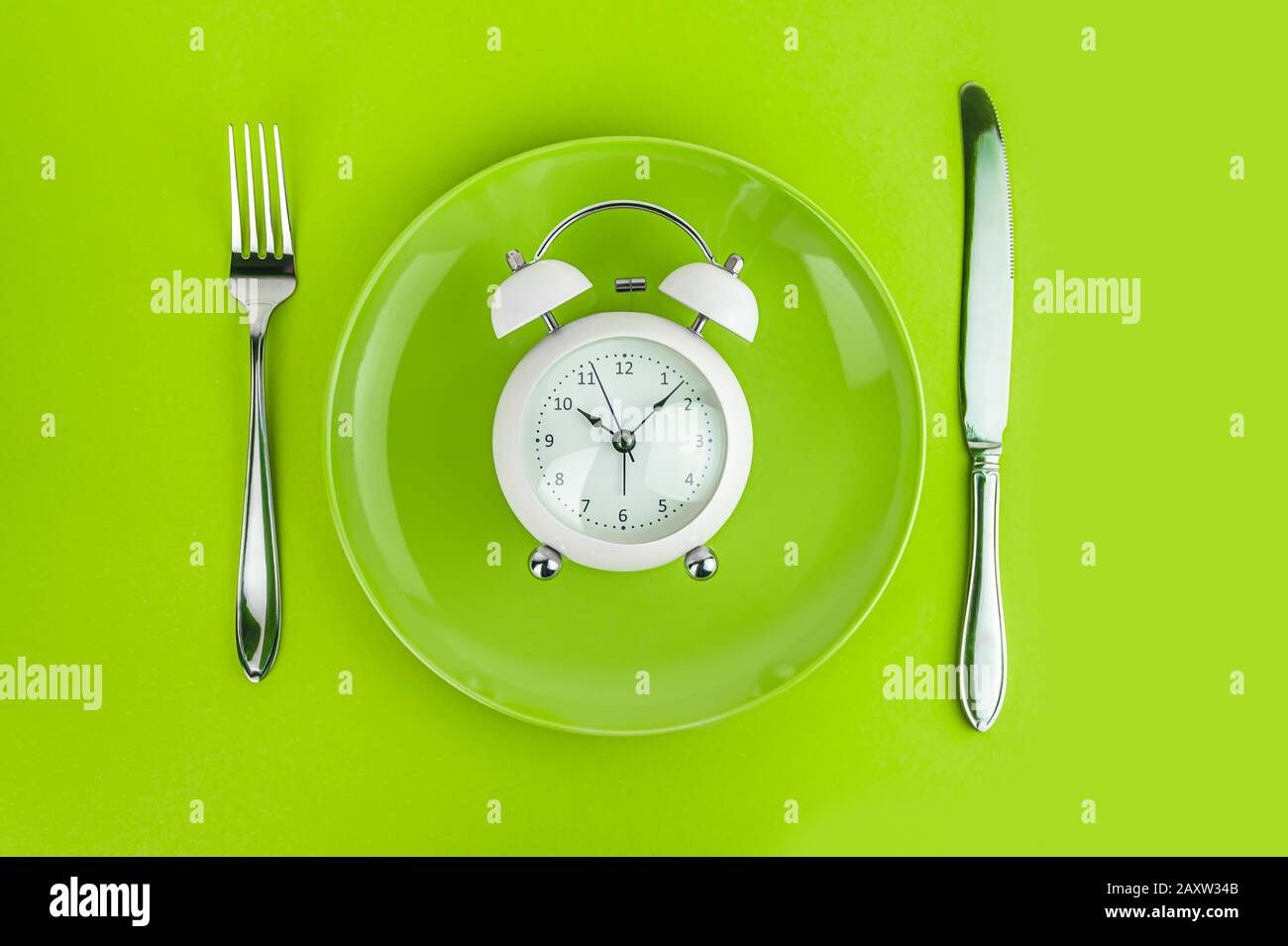 Alarm clock with fork and knife on the table. Time to eat, Breakfast