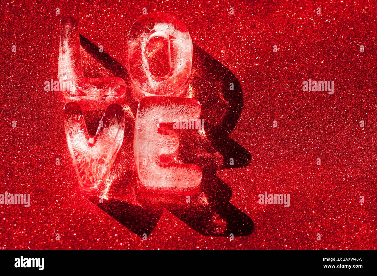 LOVE message for Valentine's Day in ice letters sparkling on passionate sparkling red background Stock Photo
