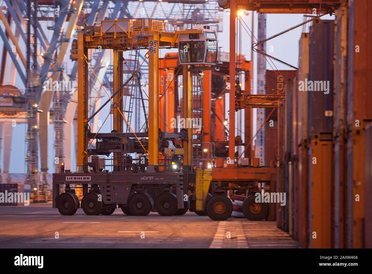 Container movers moving containers around port terminal for loading on and off ship. Stock Photo