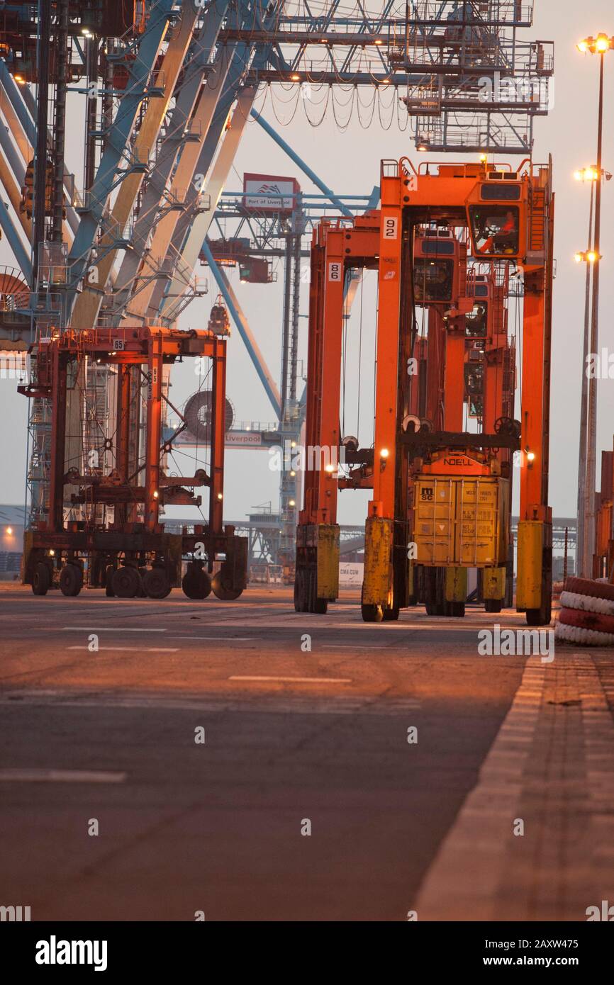 Container movers moving containers around port terminal for loading on and off ship. Stock Photo