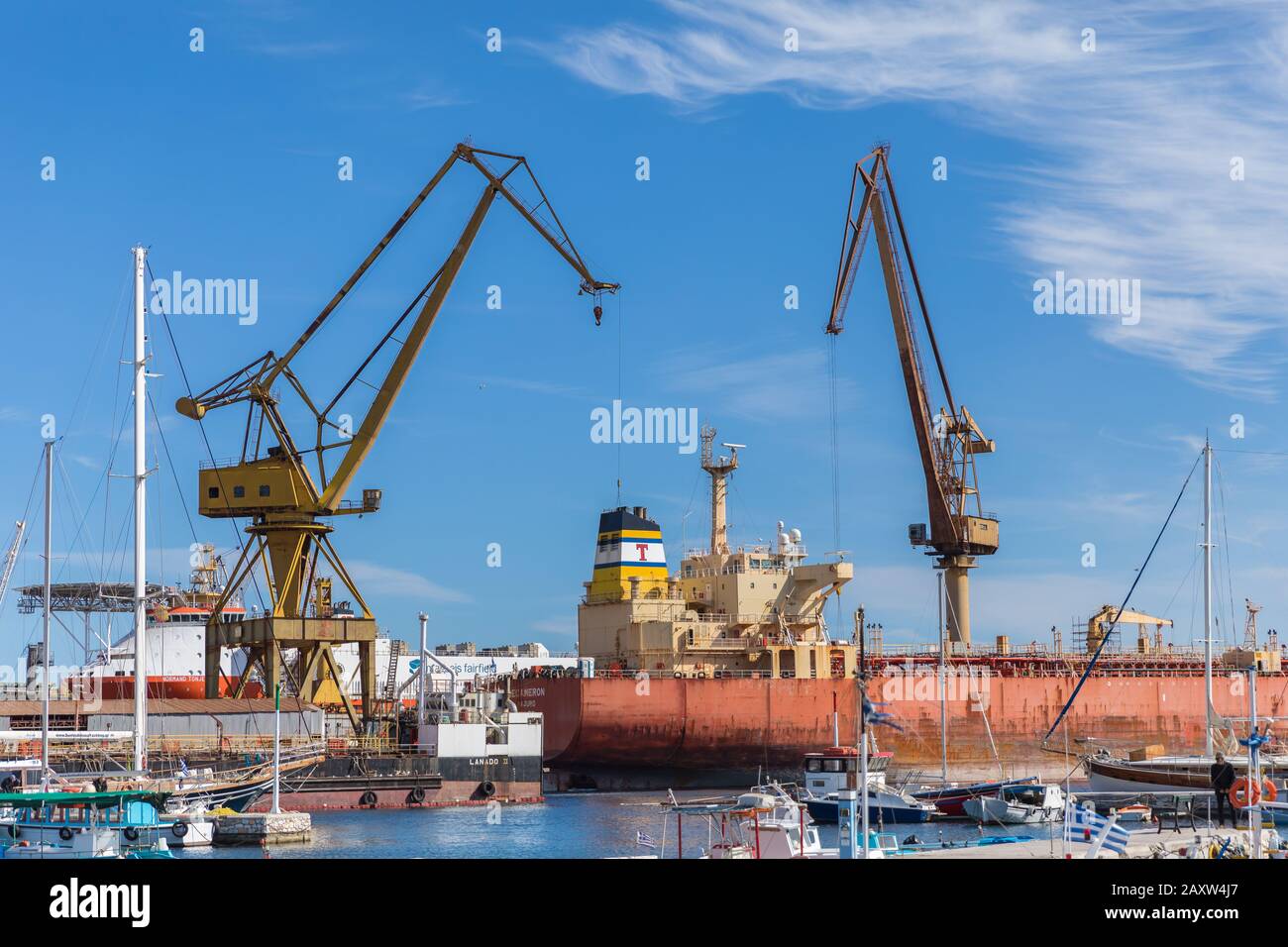 Ermoupolis: February 13th . Two big industrial cranes working on a ship in Neorion Shipyard in Syros. Syros: February 13th, 2020, Greece. Stock Photo