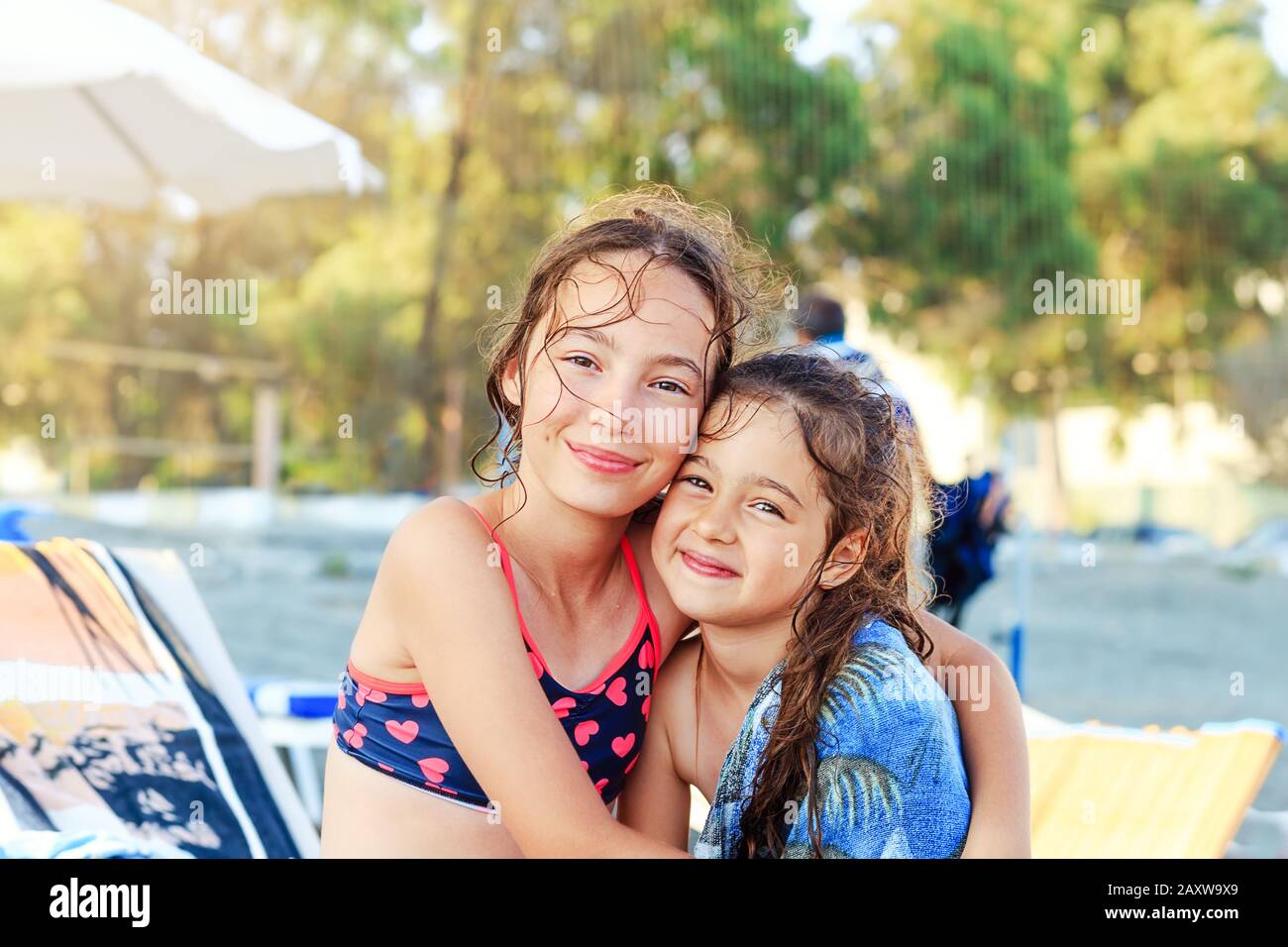 Two Cute Little Girls hugging and smiling at the Seaside at Summer Sunny Day, Ocean Coast, happy Kids concept Stock Photo