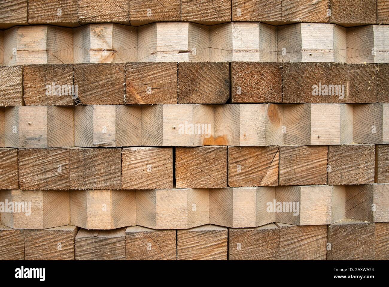 Wood stack with beveled wooden beams, texture. Close up photo of stacked wood beams in the factory Stock Photo