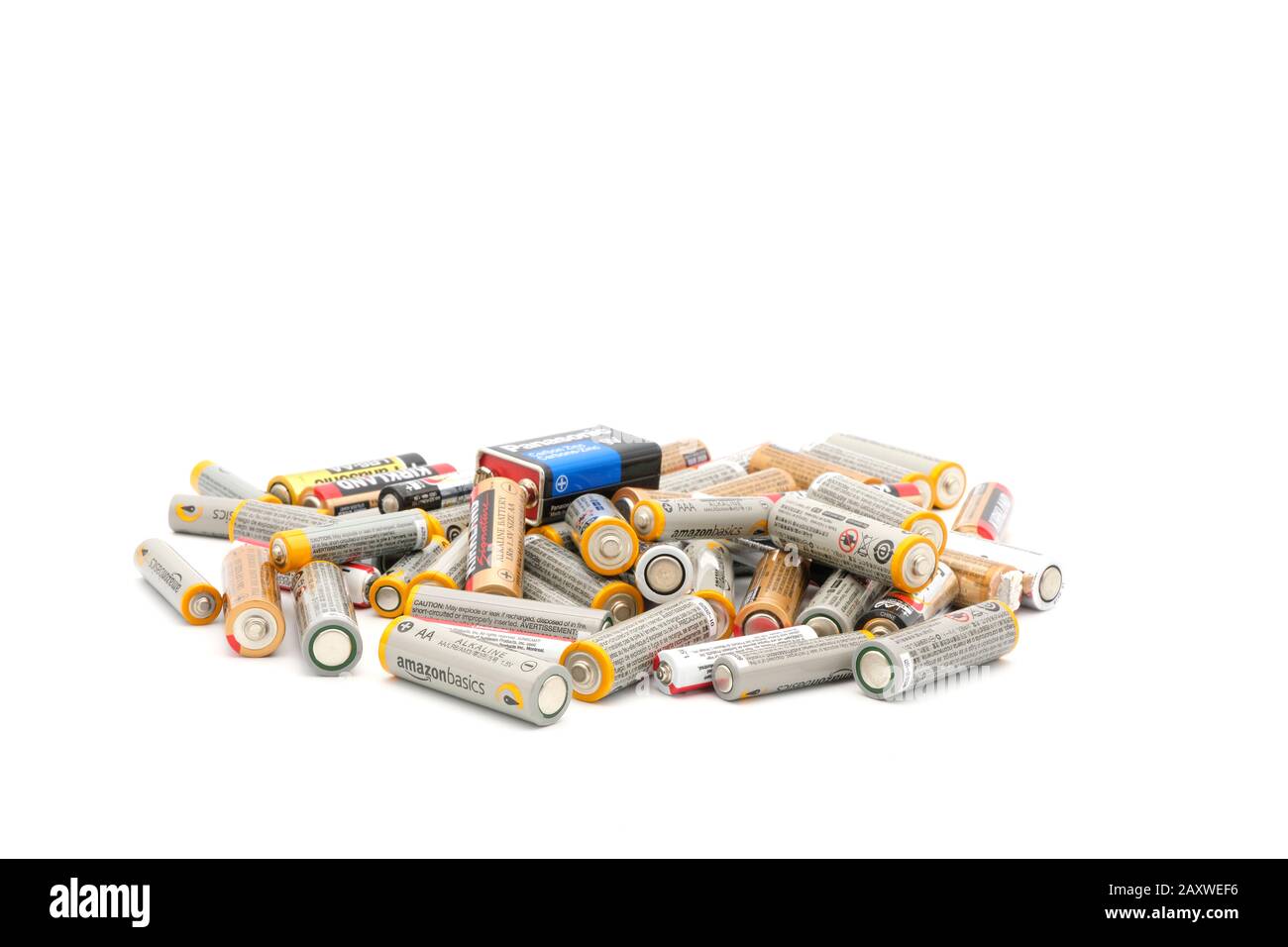 a number of used and depleted batteries photographed on a white background hinting of the need to recycle. Stock Photo