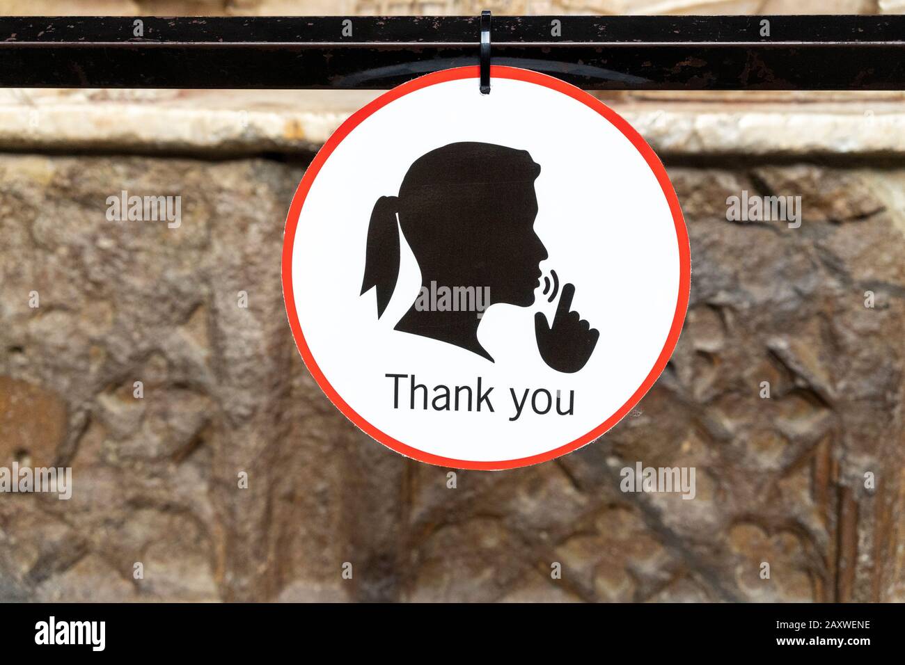 Round sign with graphic of a persons head and hand indicating a request for silence Stock Photo