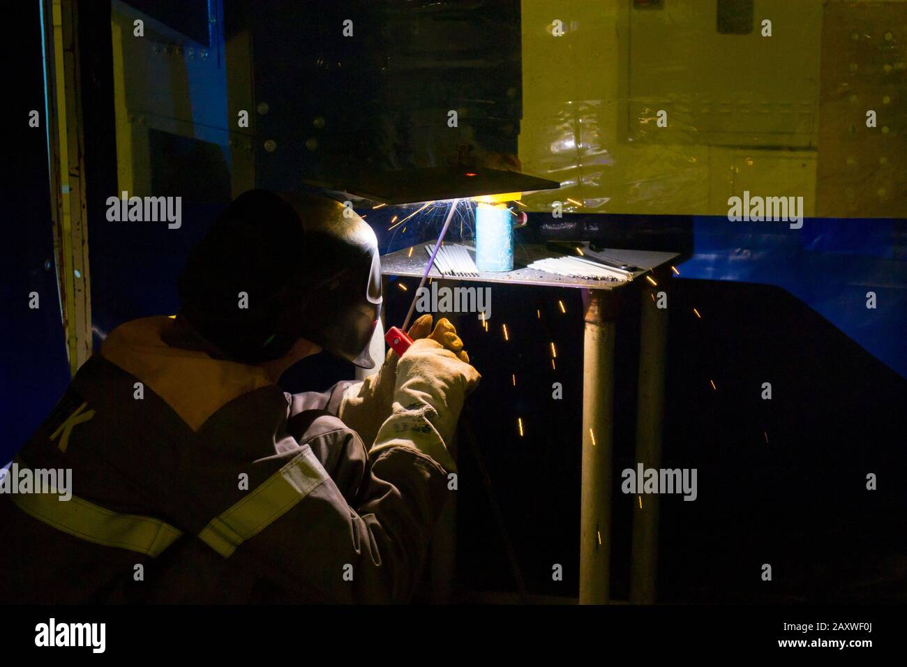 Close-up welding process. Working man in a mask welds metal. Industrial technologies, production processes. Stock Photo