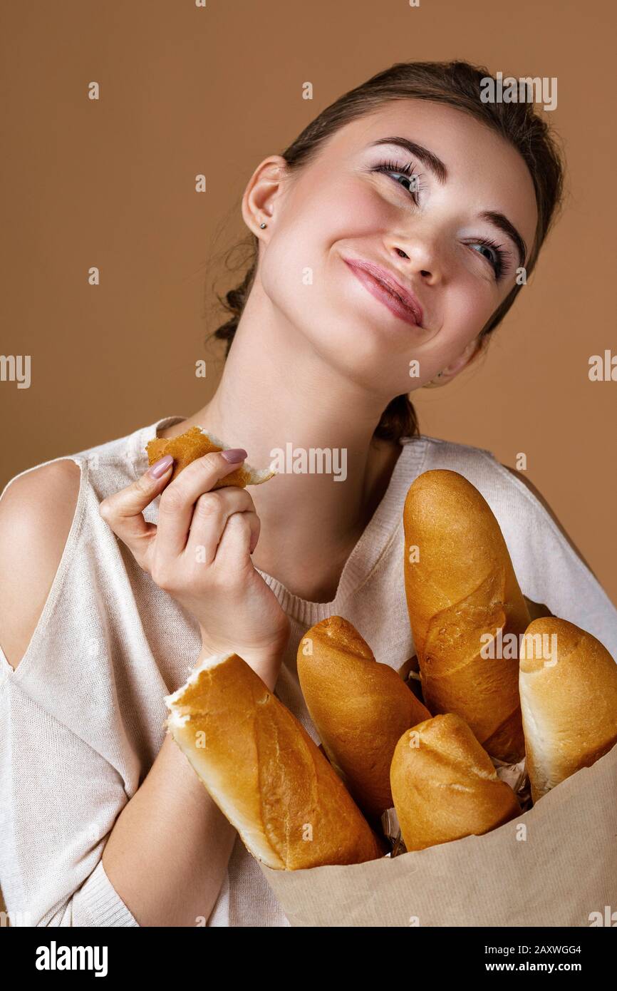 Download Portrait Of Beautiful Smiling Young Woman Holding Paper Bag With Bread On Studio Yellow Background Girl Eating Fresh Fragrant Long Loaf Stock Photo Alamy Yellowimages Mockups