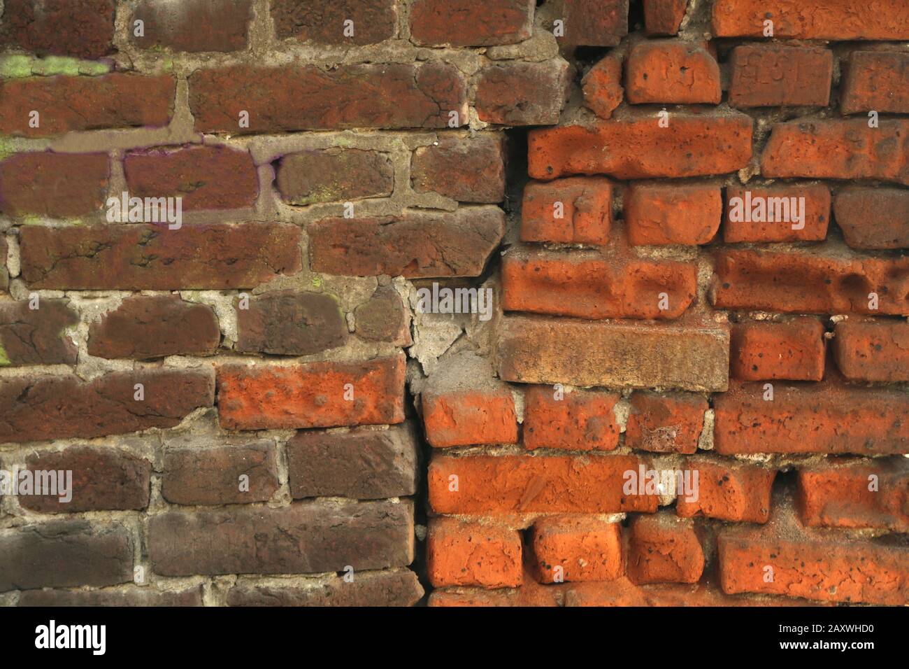 Red old worn brick wall texture background. Cracked brick wall. Two differnt colored bricks. Stock Photo