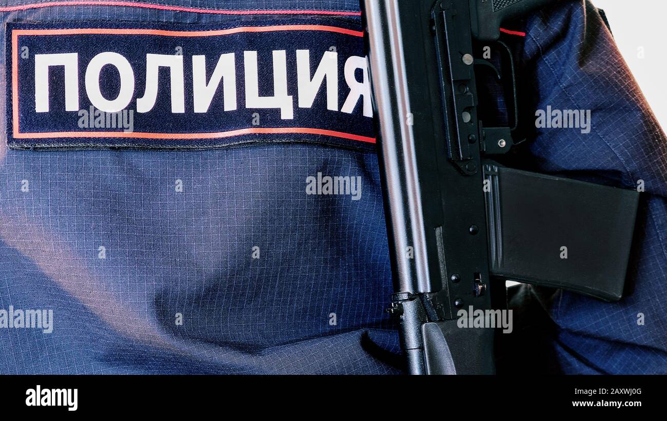 Police officer. With weapons in service. Performs official duties. The inscription in Russian police Stock Photo