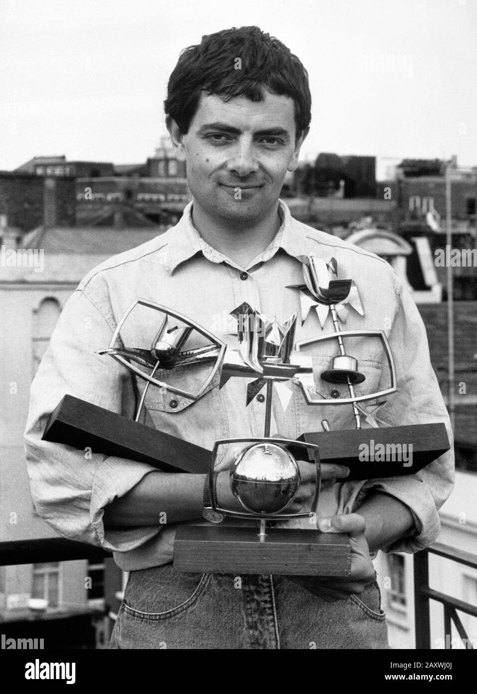 Comedian Rowan Atkinson who stars in Thames Television's Mr Bean, holding the three awards which the programme has picked up. Mr Bean is the Golden Rose of Montreal winner of 1990, and has been awarded the City of Montreal Comedy Prize and the International Press Prize. Stock Photo