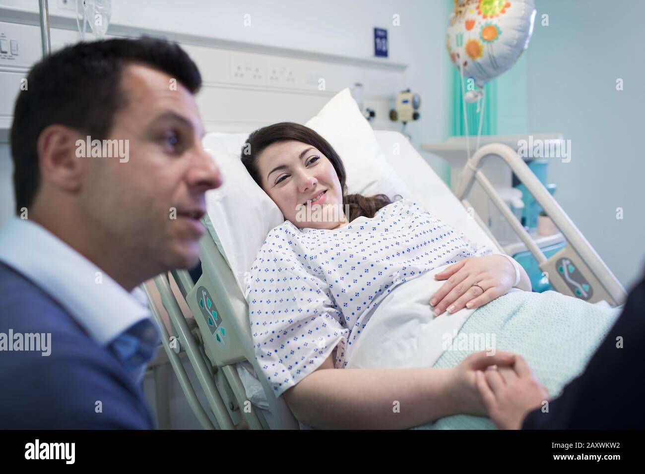 Patient visiting with family in hospital room Stock Photo