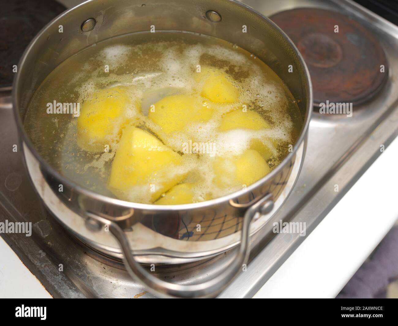 The water in a casserole with potato is about to boil, indoor closeup Stock Photo Alamy
