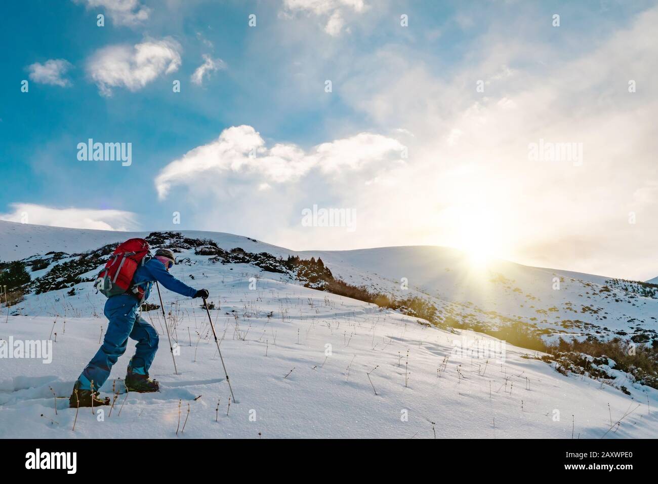 A man is engaged in skituring on split snowboarding. Sunrise is sunny in the mountains. Kyrgyzstan Stock Photo