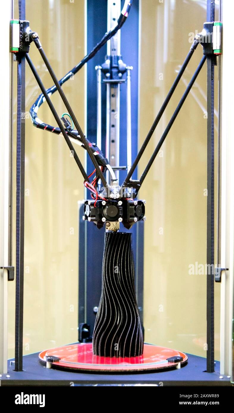 3d printer prints a model of a black vase close-up. Progressive modern ...