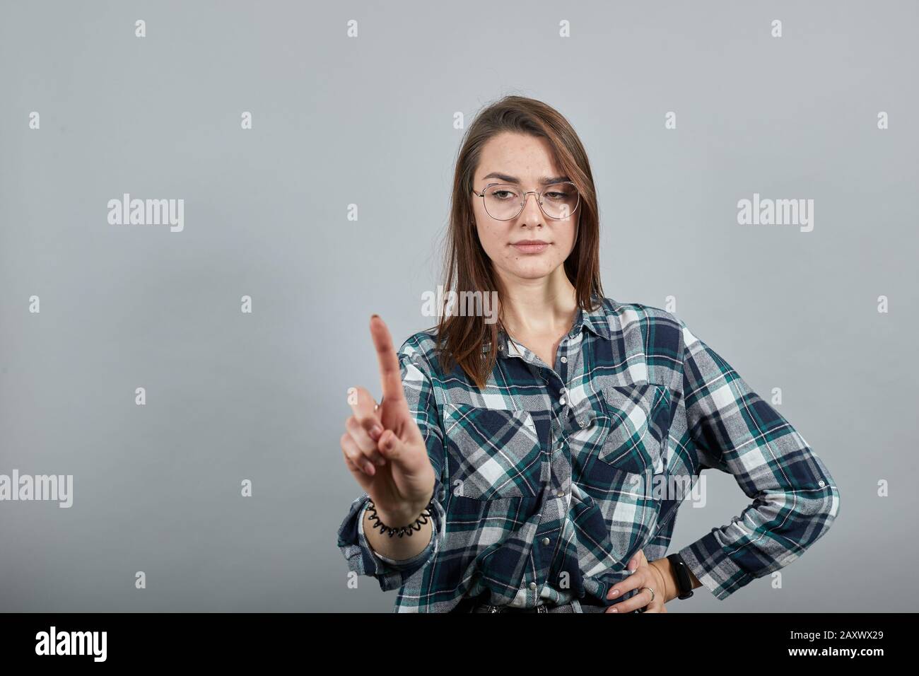 woman in glasses counteracts by shaking her index finger, a sign of disagreement Stock Photo