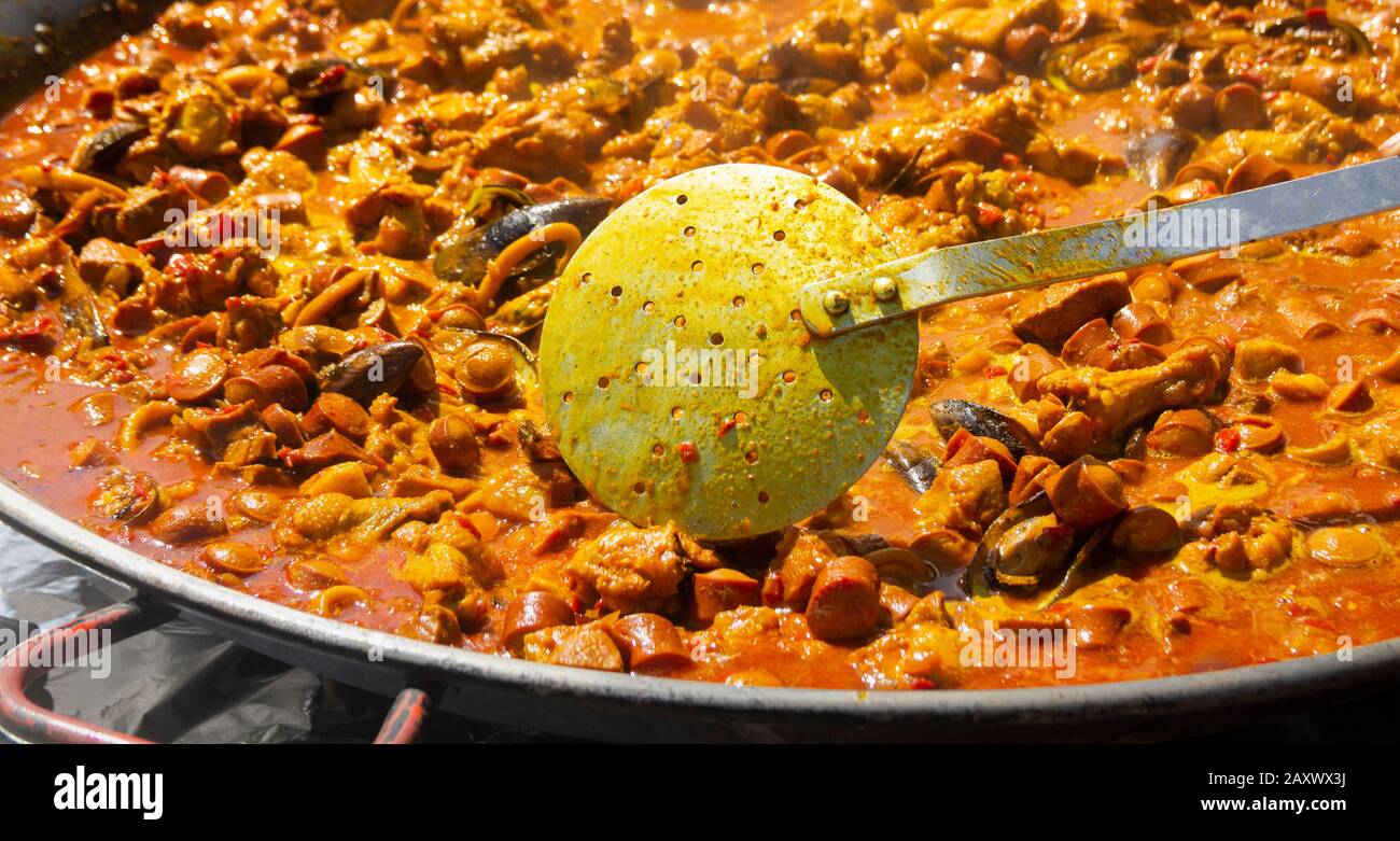 Paella being prepared at outdoor event in Spain. Stock Photo