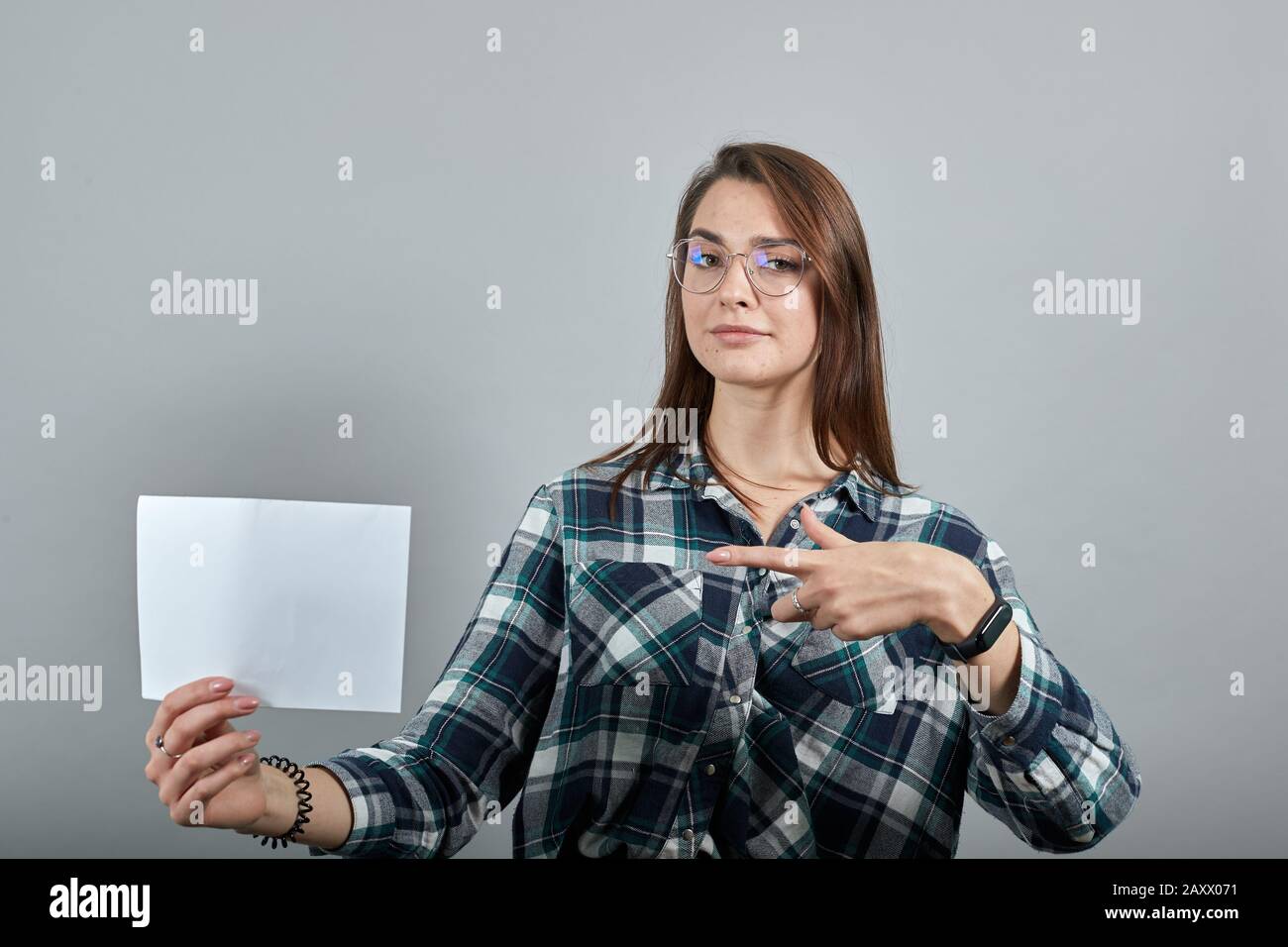 stylish woman in glasses holds a white sheet of paper in her hand Stock ...
