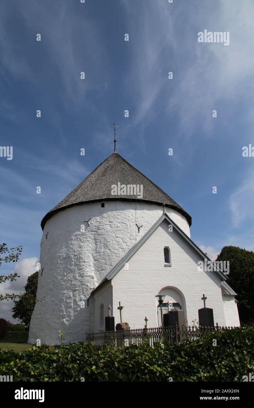Vertical shot of nylars church in aakirkeby, denmark with a clear blue sky in the background Stock Photo