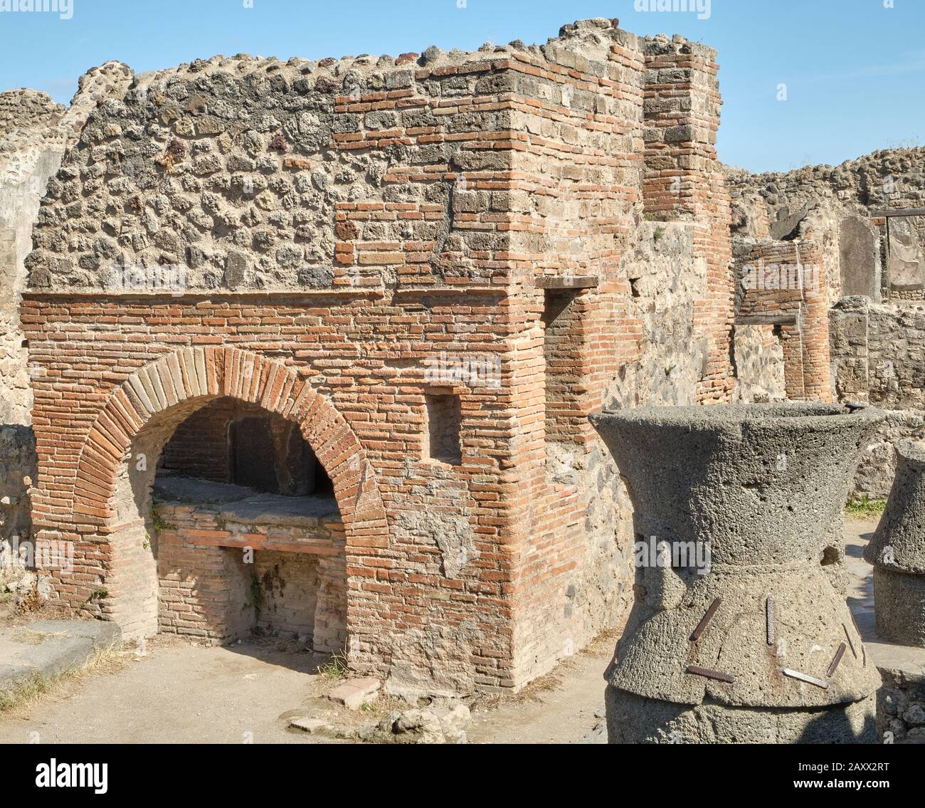 Brick bread oven and a flour mill at a bakery in the Roman ruins of Pompeii Stock Photo