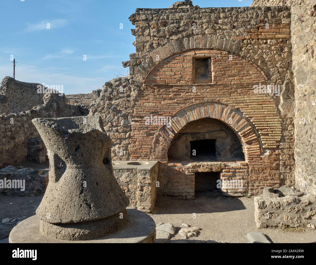 Brick bread oven and a flour mill at a bakery in the Roman ruins of Pompeii Stock Photo