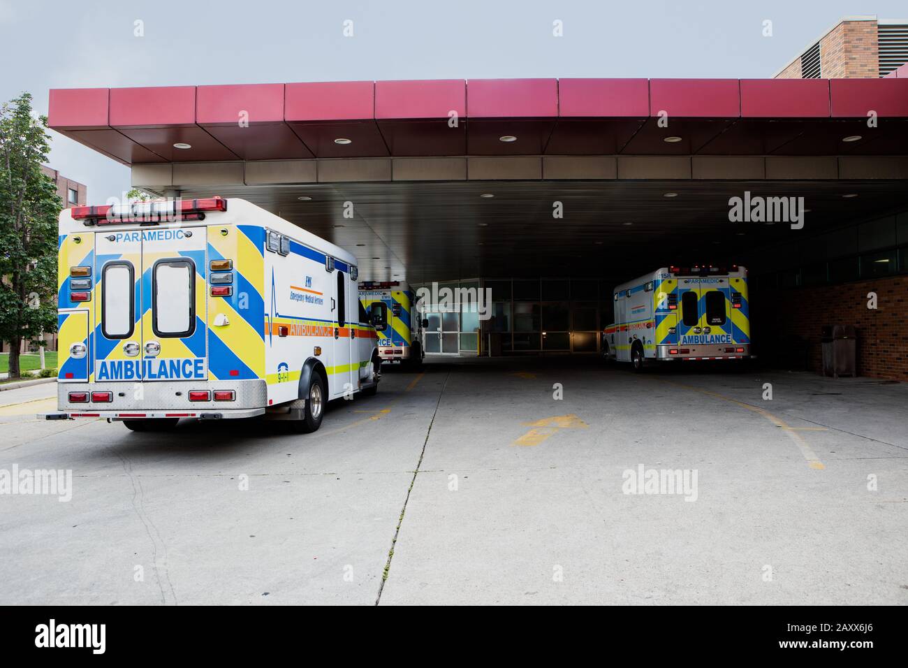 Ambulances Parked in Emergency Parking Bay Under Canopy idle waiting for an emergency Stock Photo