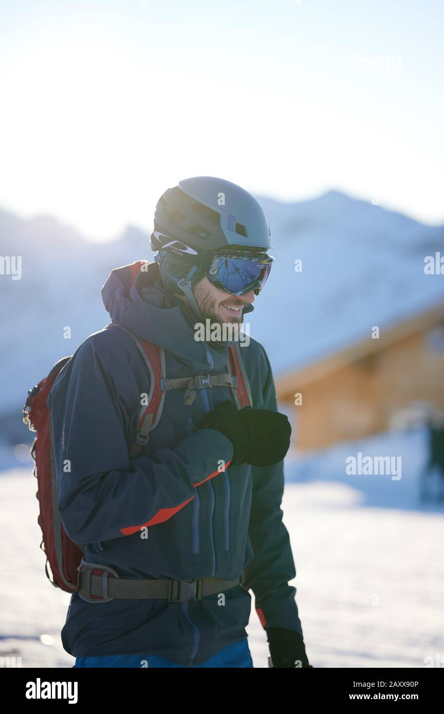 Male skier with helmet and googles in Swiss mountains during sunset Stock Photo