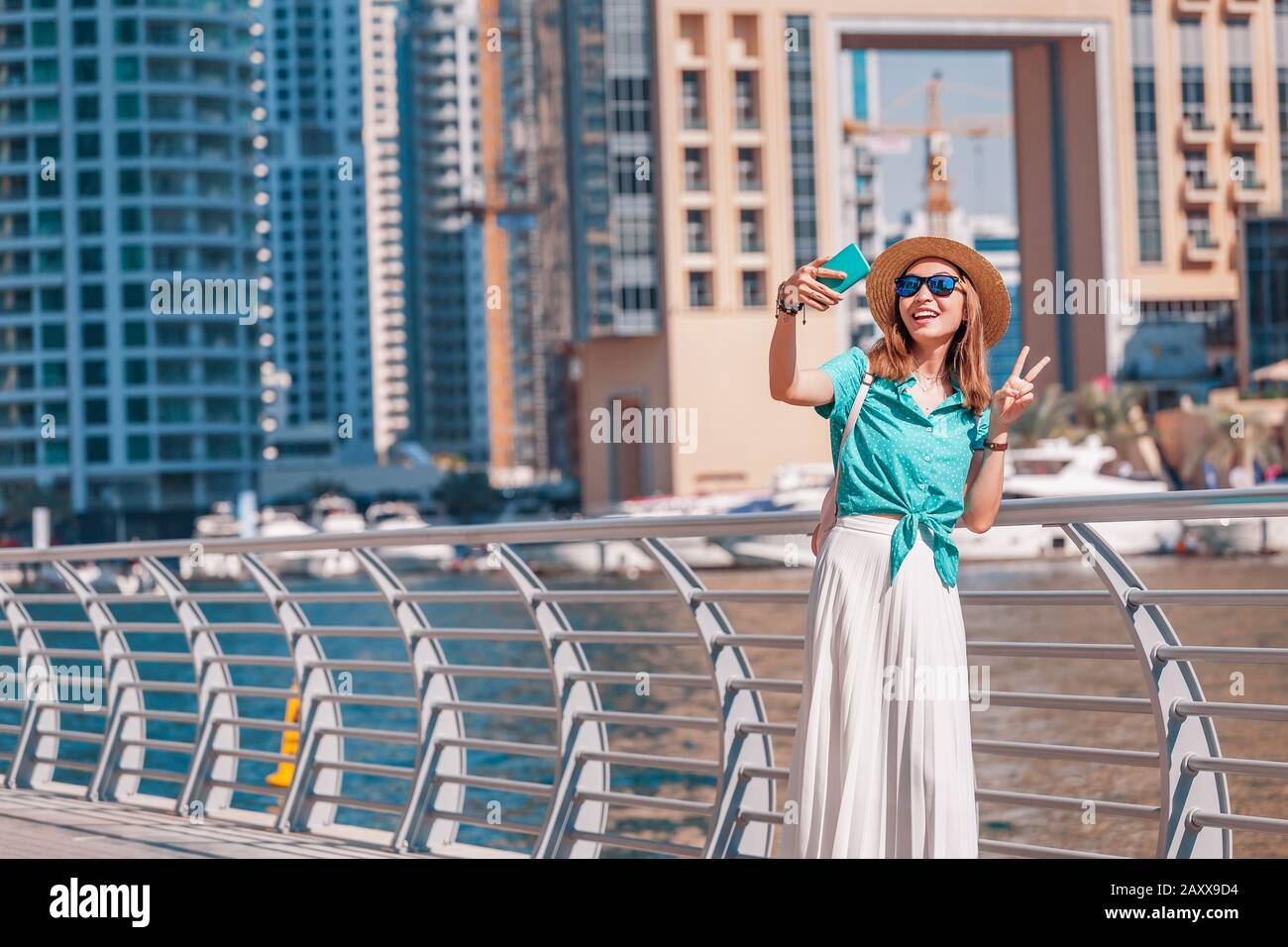 Happy asian girl taking selfie photo on a smartphone while walking on a  promenade in Dubai Marina district. Travel and lifestyle in United Arab  Emirat Stock Photo - Alamy