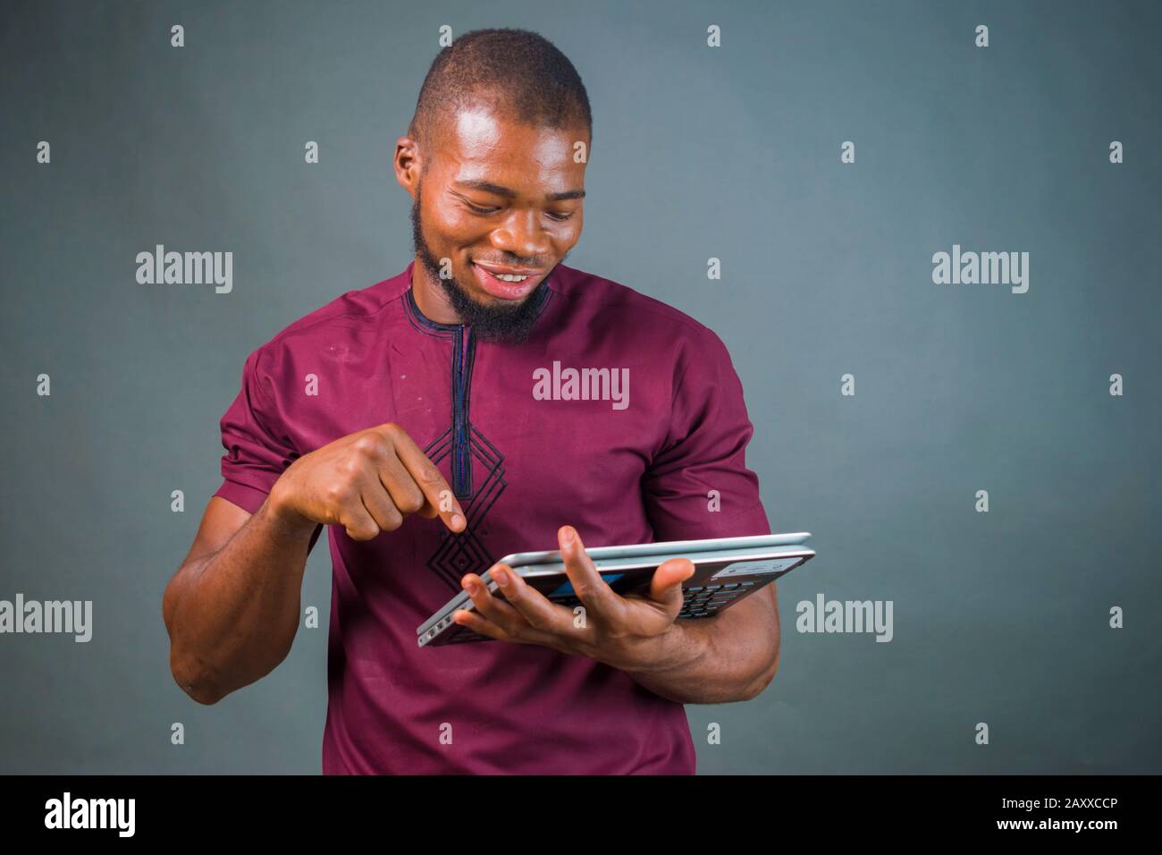 handsome young african man isolated over grey background pointing at ...