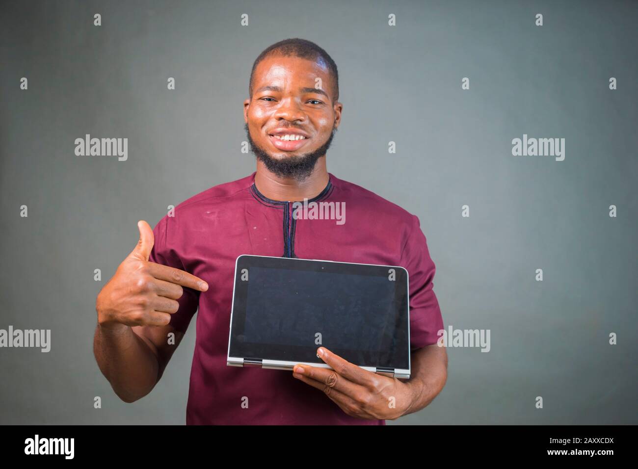 handsome young african man isolated over grey background pointing at ...