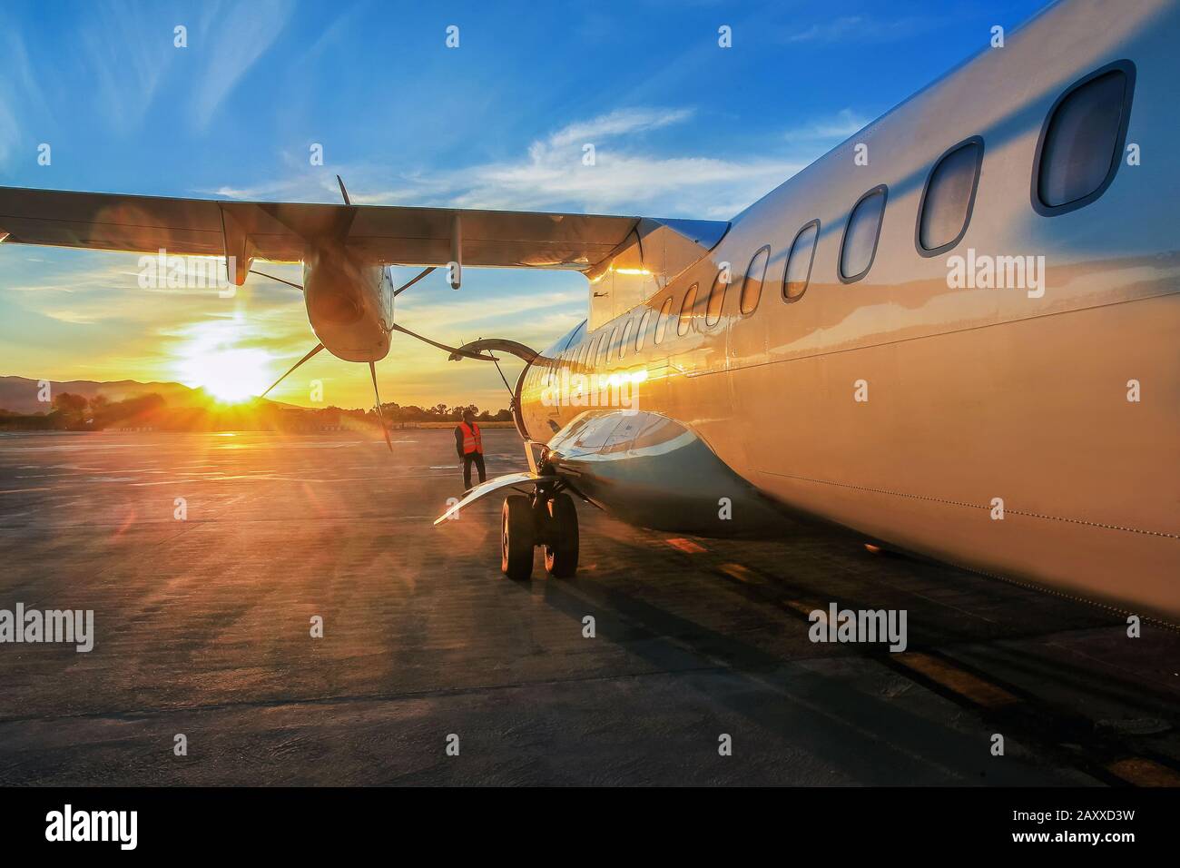 Majestic sunrise in Italian airport.  The yellow rays of the sun miraculously illuminate a plane in Italy. Stock Photo