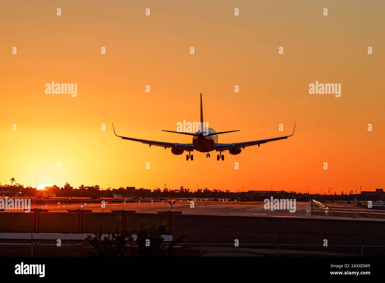 Silhouette of a jet airplane landing at sunset. Phoenix Int. Airport. Phoenix, Arizona. Stock Photo