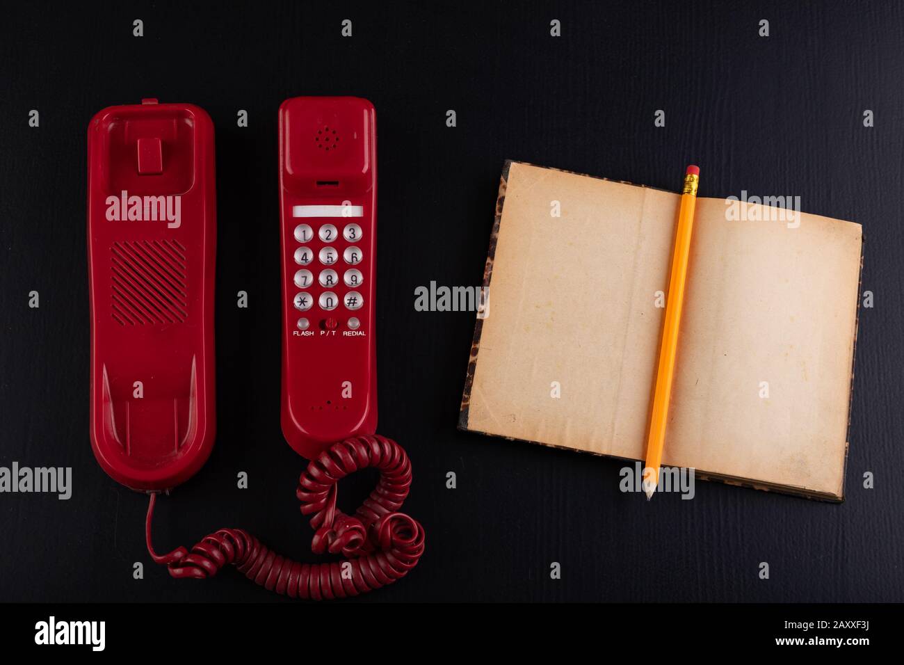 Telephone Notebook Red Old analog telephone and notebook on the desk. Office accessories in ...