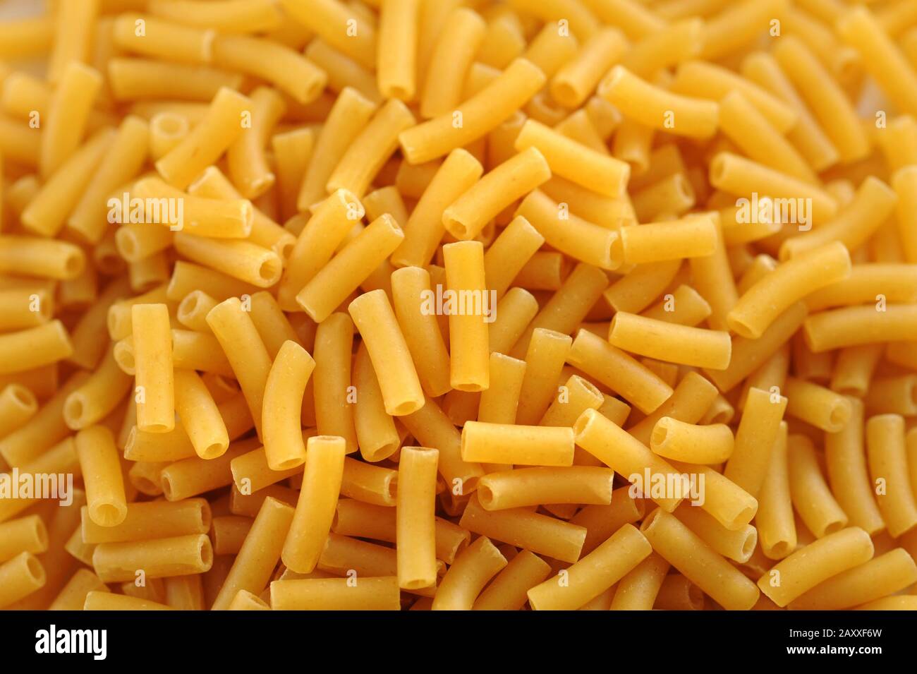 Macaroni background texture with a heap of dried pasta tubes in a full frame view for Italian and Mediterranean cuisine Stock Photo