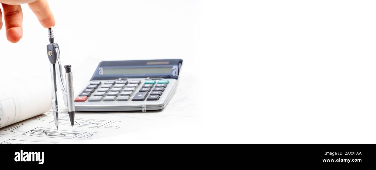 Wide banner, human hand, finger pressing down on top of a rotating compass, business calculator in the background, copy space on the right Stock Photo