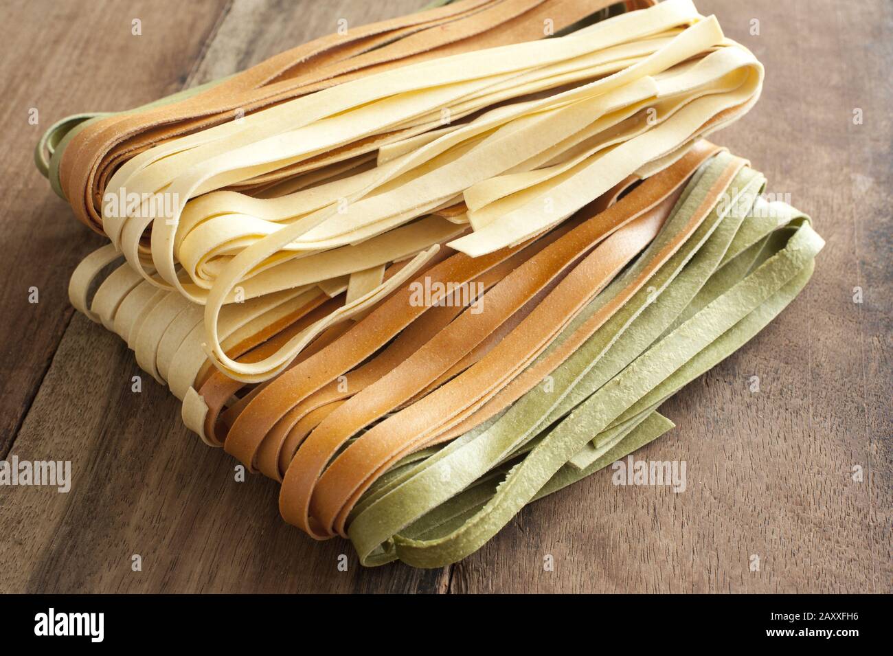 Homemade dried tagliatelle noodles in three varieties, plain, green and ...