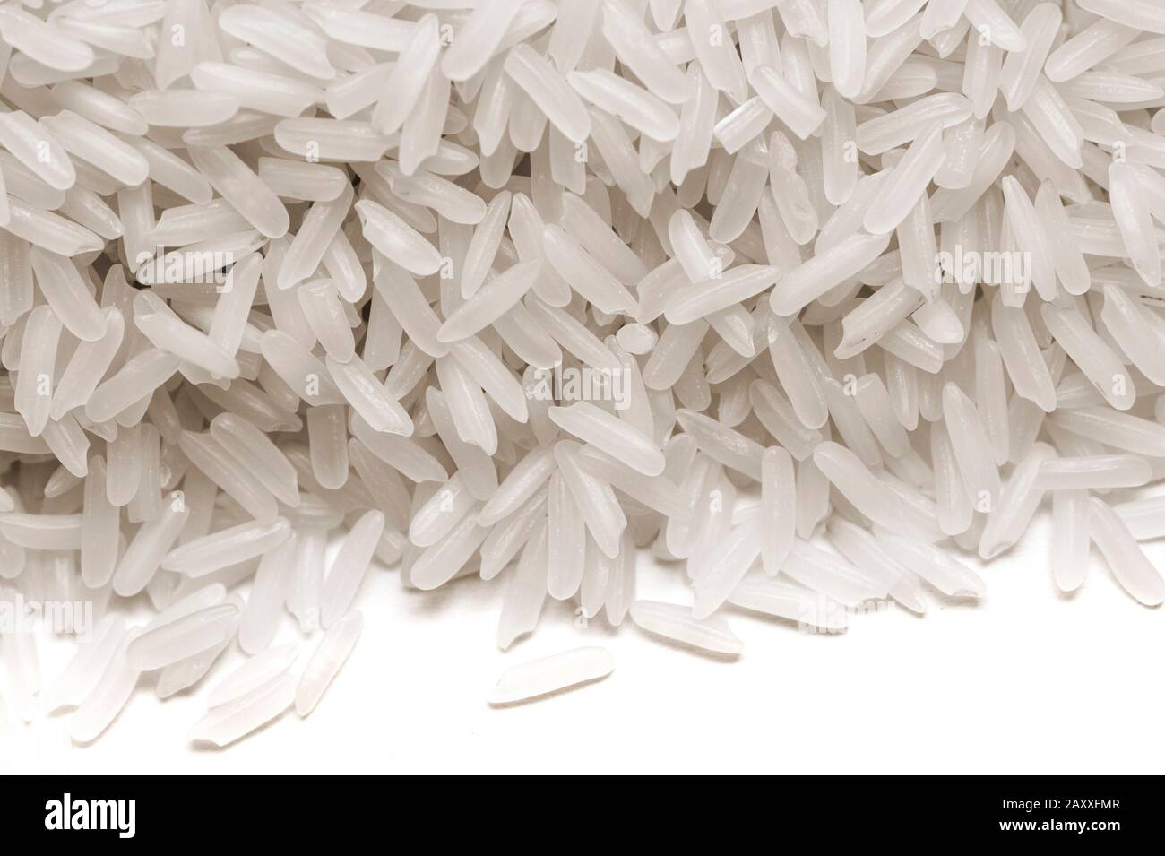 Long-grain white rice, a cereal grain high in calories and a worldwide staple in nutrition and diet which is often parboiled before being sold to cons Stock Photo