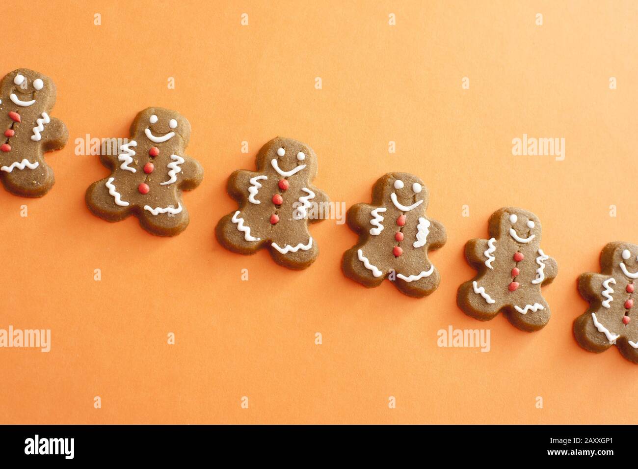 Single line of smiling gingerbread men cookies with white and red candy decorations detailing the face, arms and legs Stock Photo