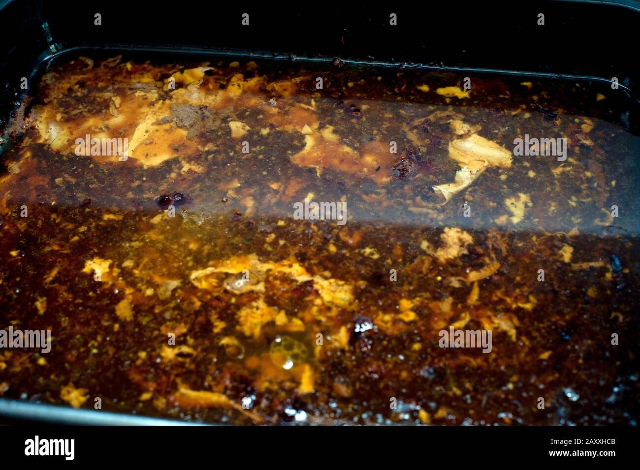 Dripping and juices in a roasting pan exuded from the meat during