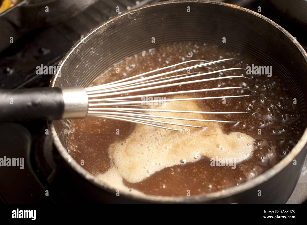 Metal Whisk Resting Over A Pot Of Boiling Gravy On A Gas Hob To Beat 