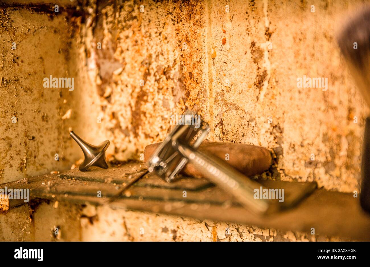 A spinning top with a vintage butterfly safety razor, in a rusty bathroom medicine cabinet. Stock Photo