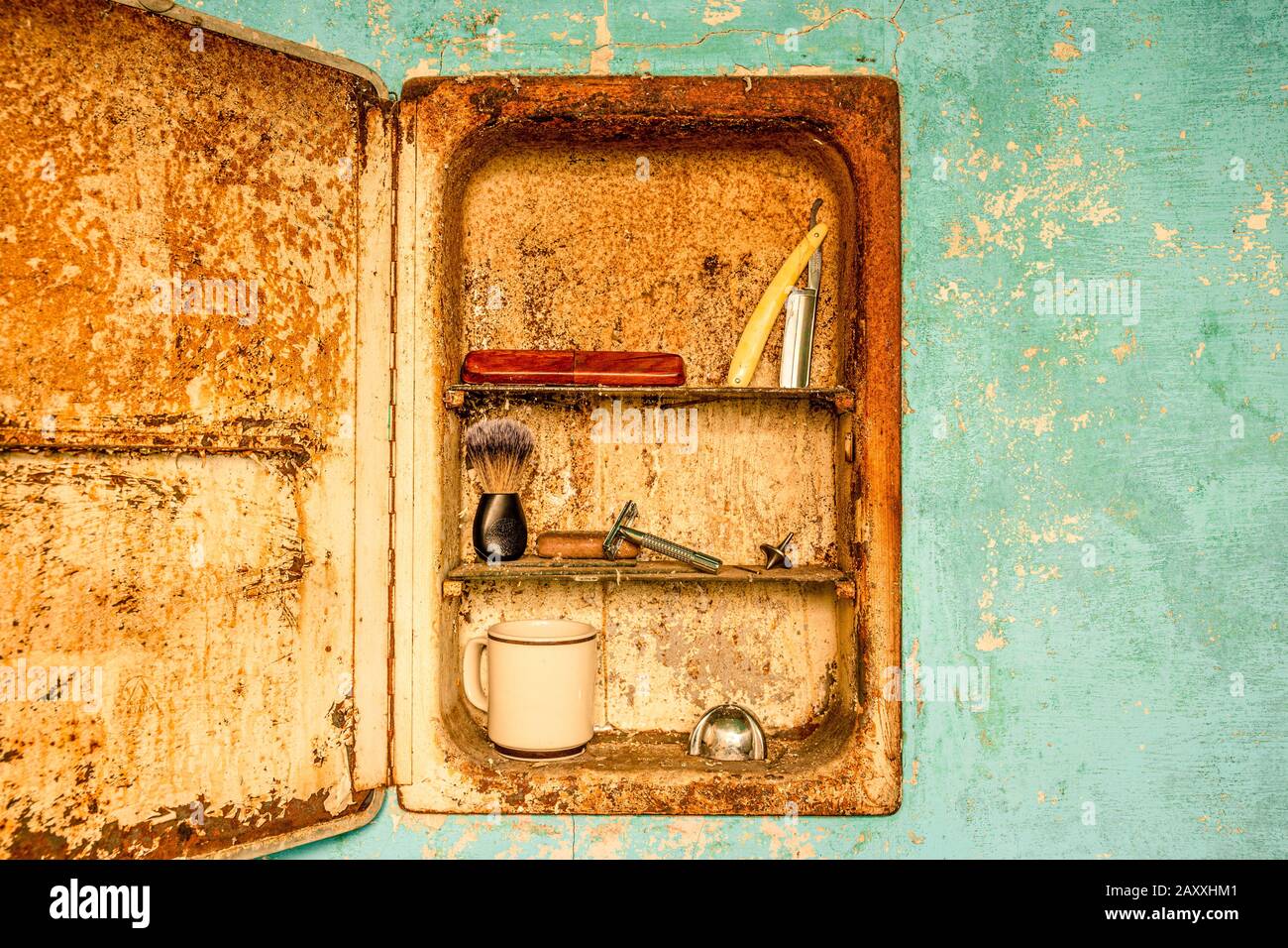 Vintage barber straight edge and butterfly razor with wood case, in a rusty bathroom medicine cabinet. Stock Photo