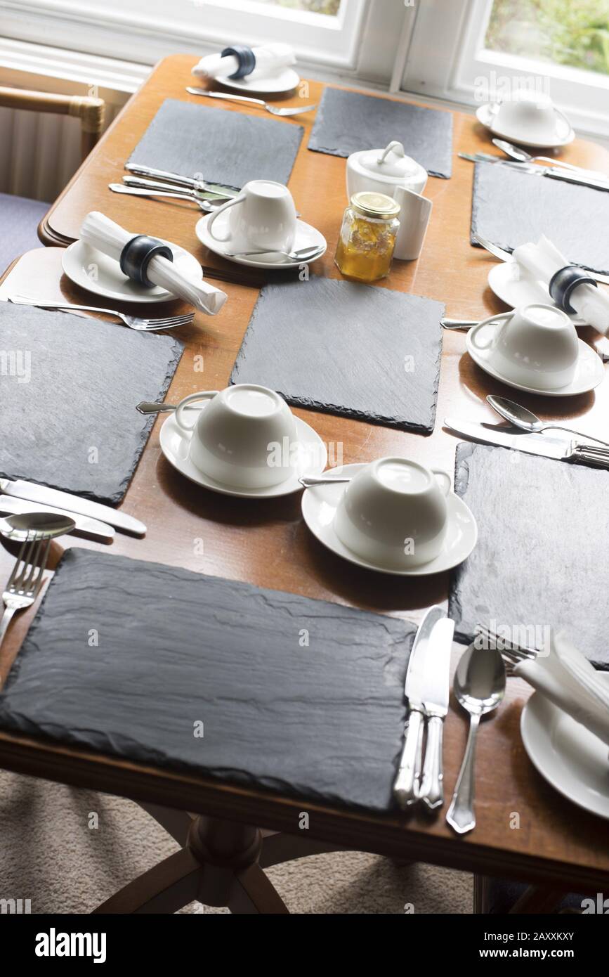 Two restaurant tables set for dinner or lunch with linen, place mats