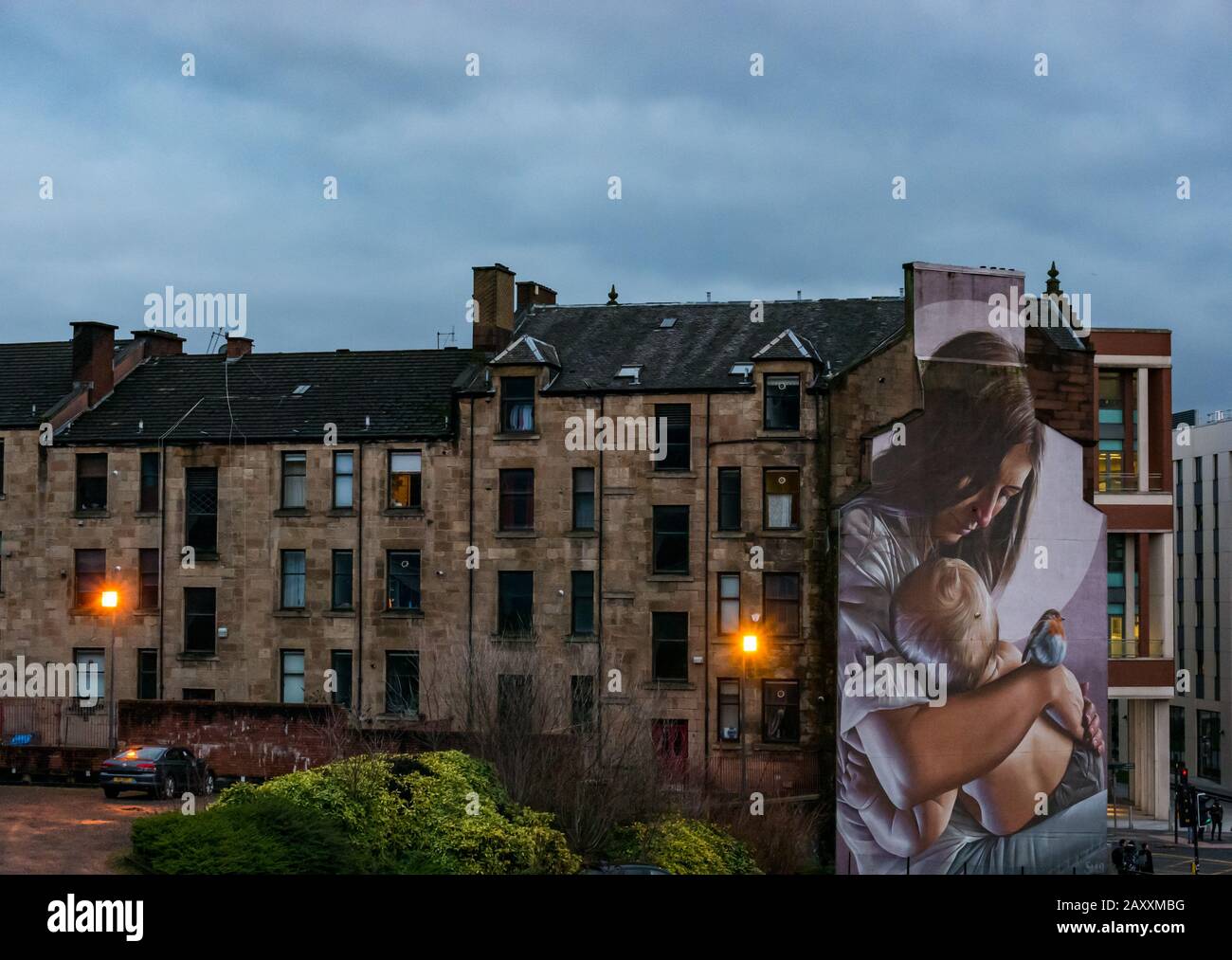 Large mural called St Enoch and Child by Smug street artist at dusk with tenement buildings, Glasgow, Scotland, UK Stock Photo