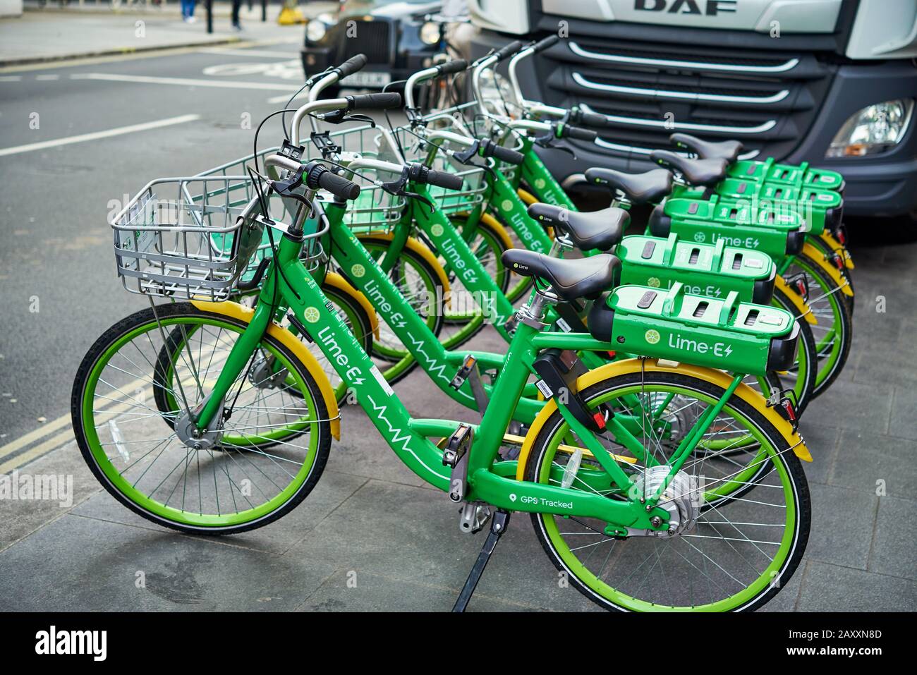 Five vivid green electric hire bicycles parked in a row on the pavement in London. Stock Photo