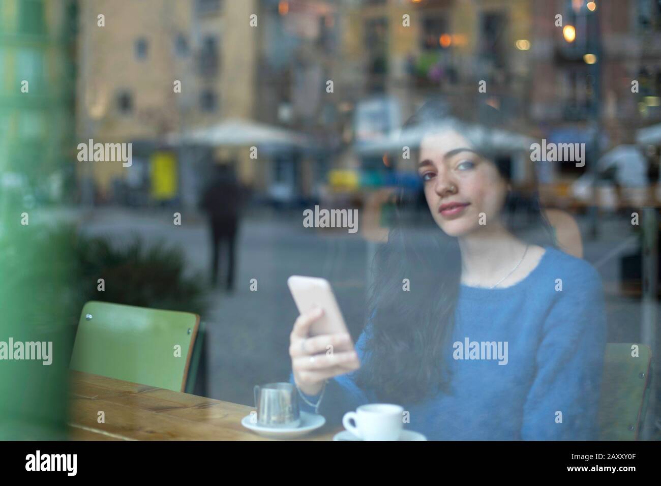Young businesswoman in a cafe- seen through window Stock Photo